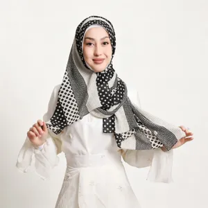 Nahaufnahme Detailansicht des eleganten schwarz-weißen Pünktchen Chiffon Kopftuchs und Hijab.