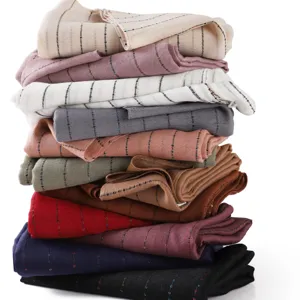 Detailed view of stacked colorful striped lightweight cotton linen scarves, texture.