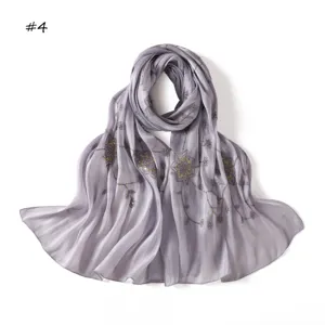 Detail view of grey purple silk scarf with delicate web sequin embroidery texture.