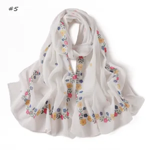Close-up detail of white chiffon scarf with vibrant floral print, soft and lightweight.
