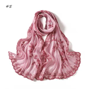 Detailed view of pink embroidered sequin scarf showcasing delicate floral lace edge texture.