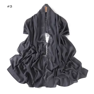 Dettaglio sciarpa lunga in chiffon grigio scuro, ricamo floreale, delicato bordo in pizzo.