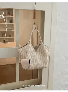 Detailed view of beige woven leather tote bag hanging on glass door, elegant craftsmanship.