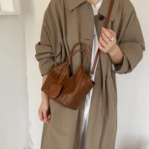 Woven leather bucket bag for women, stylish brown shoulder crossbody tote with top handle.