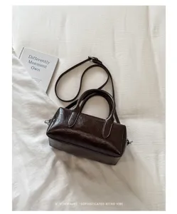 Dark brown retro boston pillow bag detail view showing glossy PU texture and dual handles.