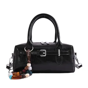 Black patent leather Boston handbag for women, chic top handle pillow bag with shoulder strap.