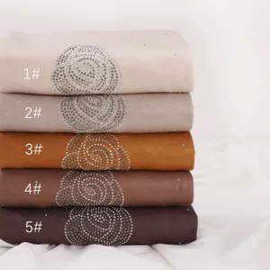 Detailed view of stacked modal rhinestone scarves in earthy tones, soft textured fabric.