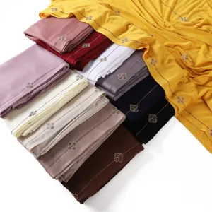 Detailed view of solid color mercerized cotton jersey long scarf with rhinestone clover pattern.