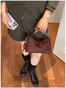 Vista dettagliata della borsa a spalla marrone vintage con elegante trama rétro chic.