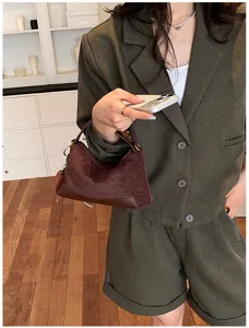 Primo piano dettagliato di una borsa a mano marrone testurizzata retrò, elegante stile autunnale.