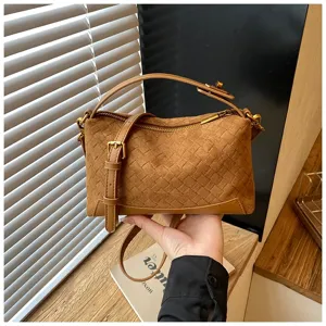 Vista dettagliata della borsa a tracolla intrecciata marrone con manico superiore in stile.
