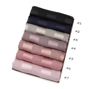 Detailed close-up view of rolled silk-feel satin scarves in assorted vibrant colors.