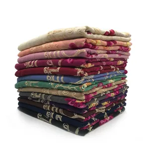 Gedetailleerd overzicht van gestapelde vintage geborduurde sjaals in diverse kleuren.