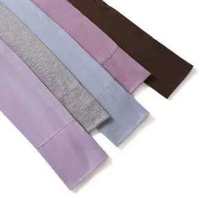 Detailopname van zachte modal katoenen armhoezen in effen kleuren met fijn stikwerk.