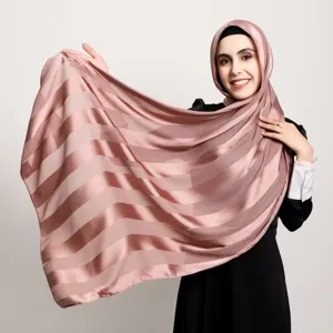 Detail shot of pink striped satin hijab, soft breathable long scarf for travel and daily wear.