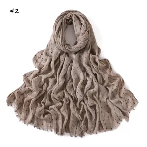 Gros plan sur le foulard en rayonne rayé avec des fils d'argent et des franges.