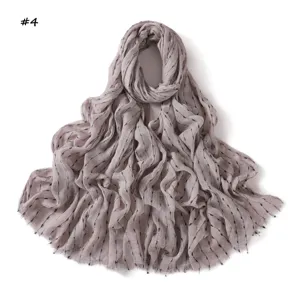 Écharpe légère en coton et lin gris avec des détails de rayures argent et noir.