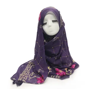 Detail paarse hijab sjaal, gouden grid patroon, roze bloemen borduurwerk, kwastjes franje.