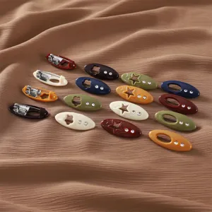 Close-up view of colorful oval safety pins featuring hollow star patterns with rhinestone accents.
