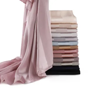 Detailed view of solid color imitation silk long scarves with wide stripes and soft satin.