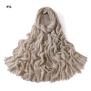 Écharpe en coton et lin beige avec fils argentés, rayures noires et franges pour femme.