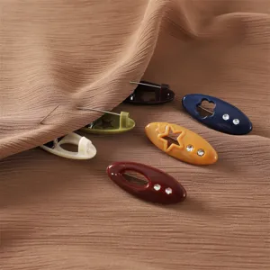 Close-up detail of colorful plastic safety hijab pins featuring hollow star and crystal rhinestones.