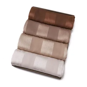Detailed view of luxury satin silk long scarves with jacquard leopard patterns and wide stripes.