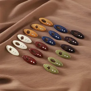 Close-up detail of colorful plastic decorative safety pins with star and flower rhinestone cutouts.
