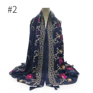 Gedetailleerd overzicht van de donkerblauwe vintage geborduurde sjaal met kwastjes en bloemen.
