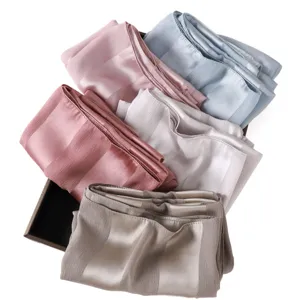 Detailed view showing soft solid color minimalist fashion wide stripe imitation silk long scarf.