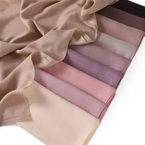 Detailaufnahme von glänzenden Chiffon-Quadrat-Schal-Stoffmustern in eleganten Farben.