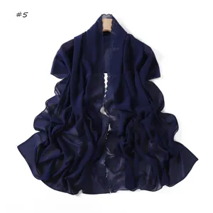 Vista dettagliata della sciarpa in chiffon blu scuro con delicati ricami floreali.