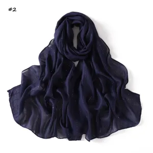 Close-up detail of navy blue long scarf featuring sparkling colorful sequin stripes.