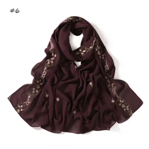 Close up view of the sheer dark purple scarf featuring delicate floral ribbon embroidery details.