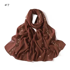 Detailed view of the brown chiffon scarf featuring delicate embroidered floral and bow patterns.