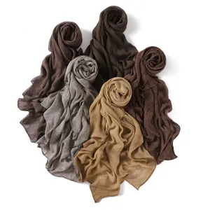 Soft crinkle cotton headscarf detail, fine textured breathable shawl in neutral tones.
