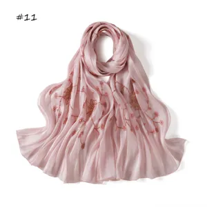 Pink silk satin scarf featuring delicate spider web sequin embroidery and soft drape.