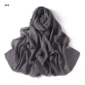 Detail shot of dark grey lightweight stripe sequin scarf, versatile gauze shawl for women.