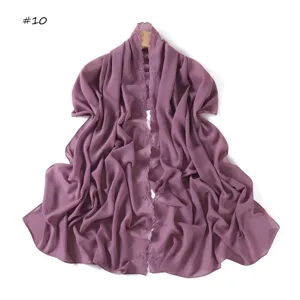 Vista dettagliata della elegante sciarpa in chiffon viola con delicato ricamo floreale.