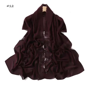 Dettaglio sciarpa in chiffon bordeaux con delicato ricamo floreale e tessuto leggero.