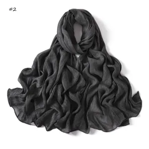 Detailed view of the dark grey crinkled cotton scarf with rolled edges and soft texture.