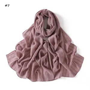 Detail shot of the lightweight mauve scarf featuring vertical stripes and sparkling sequins.