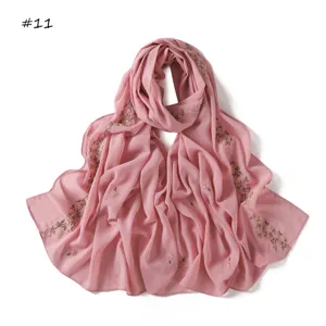 Detailed view of pink embroidered floral scarf, featuring delicate bow and rose embroidery.