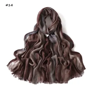 Brown gradient crinkle scarf detail shot, soft rayon pleated texture with fringe trim.