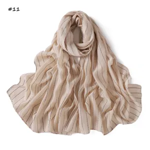 Detailed view of lightweight striped scarf with shimmering sequins, soft fabric texture.