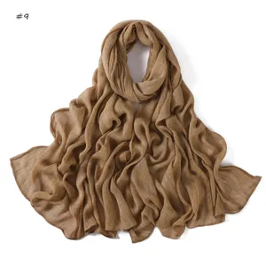 Detailed view of a solid brown crinkle rayon scarf with rolled edges and breathable fine stripes.