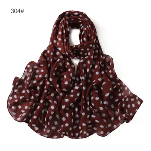 Chiffon scarf detail view, breathable lightweight fabric with classic white polka dot pattern.