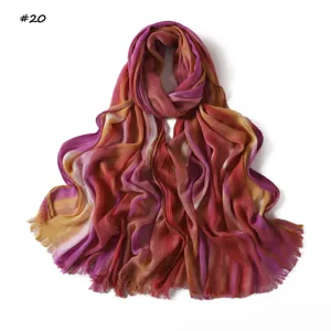Close-up detail of gradient crinkle rayon scarf with soft pleated texture and fringe edges.