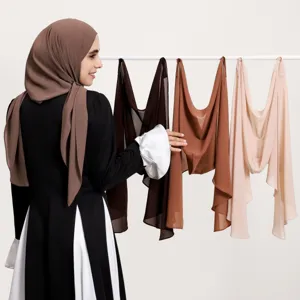 Détail de hijab en mousseline tissu doux et léger suspendu sur support avec modèle.