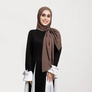 Hijab en mousseline marron unie associé à une élégante robe noire et blanche, tissu doux et fluide.